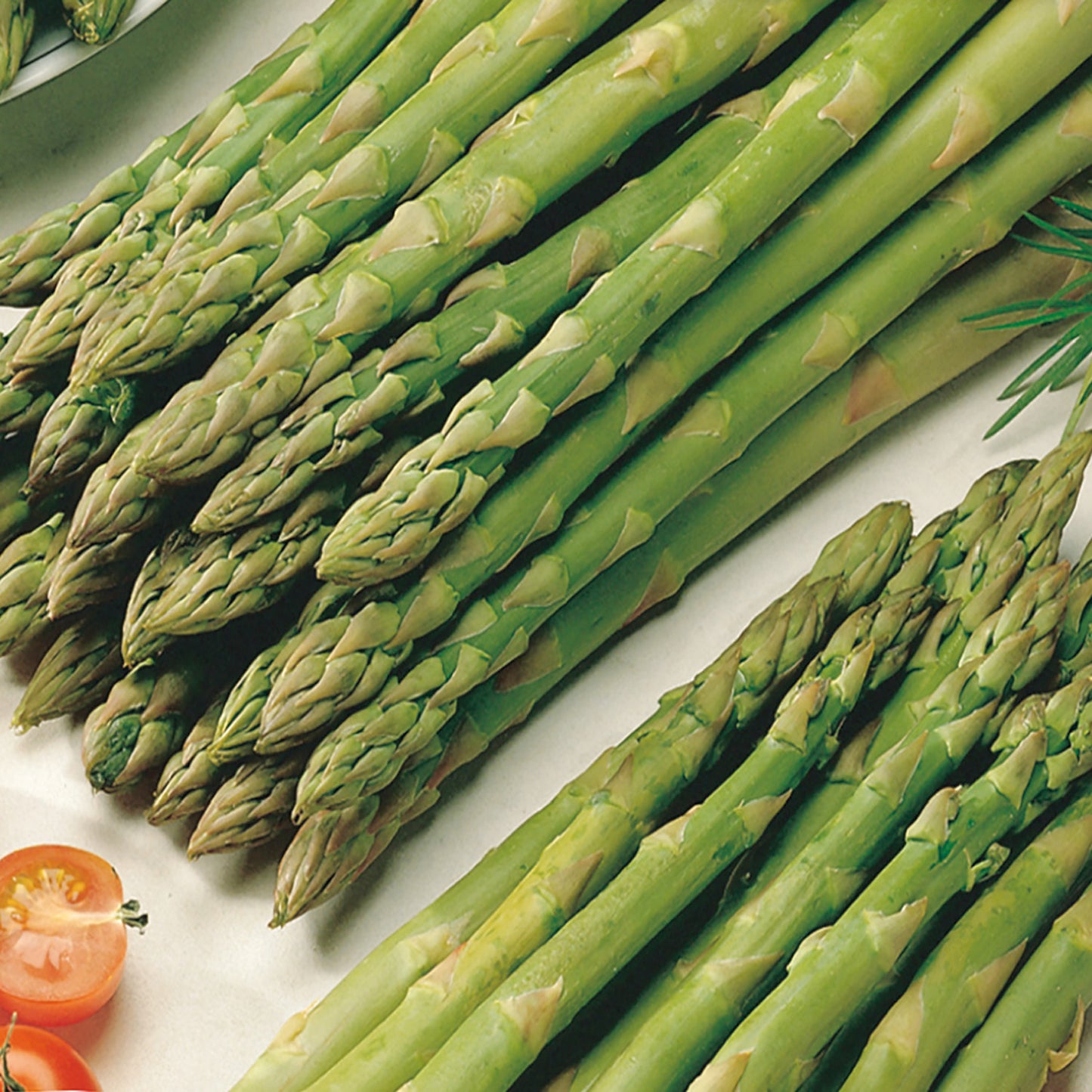 A bunch of fresh green asparagus stalks displayed on a table.