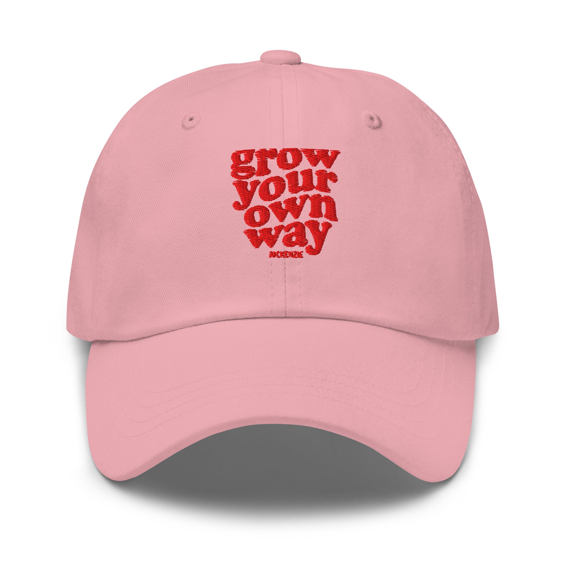 A light pink baseball cap with red embroidered text shown on a clean white background.