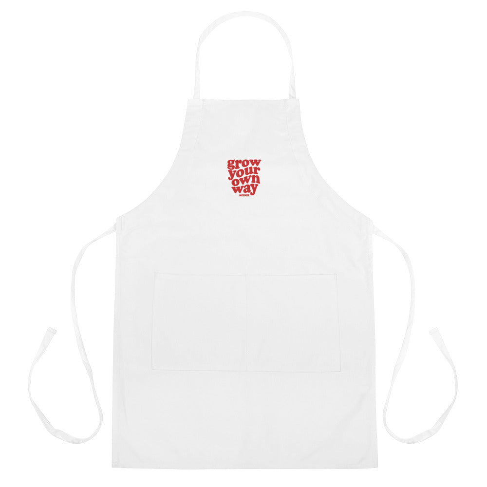White apron with red text 'Grow Your Own Way' on a white background