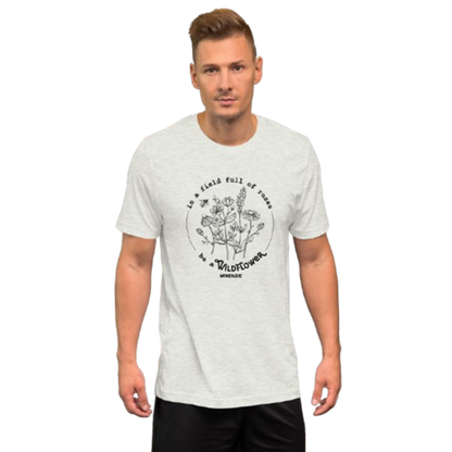 A man wearing a light heather gray t-shirt with a black circular graphic on the chest 