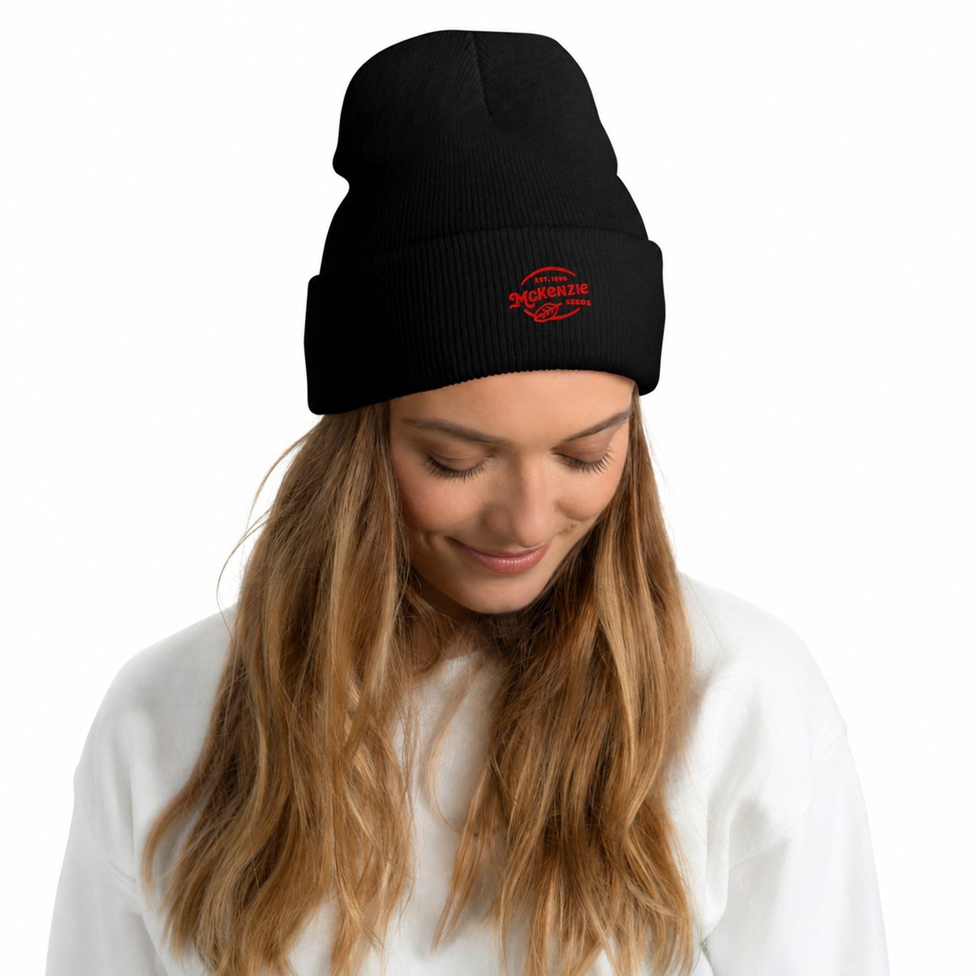 Woman wearing a black beanie with red text against a white background