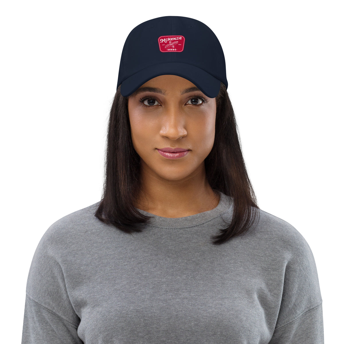 Woman wearing a navy blue cap with a logo on a white background