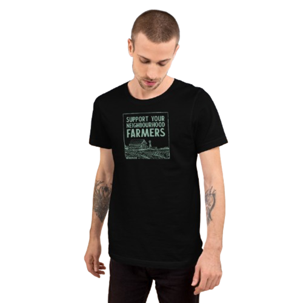 A man wearing a black short-sleeve t-shirt with a green graphic that reads 'SUPPORT YOUR NEIGHBORHOOD FARMERS' above a farm illustration, set against a plain white background.