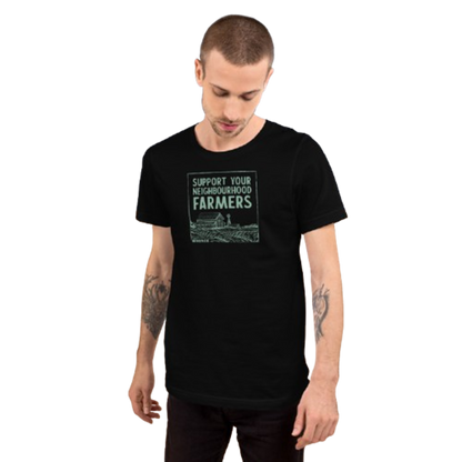 A man wearing a black short-sleeve t-shirt with a green graphic that reads 'SUPPORT YOUR NEIGHBORHOOD FARMERS' above a farm illustration, set against a plain white background.