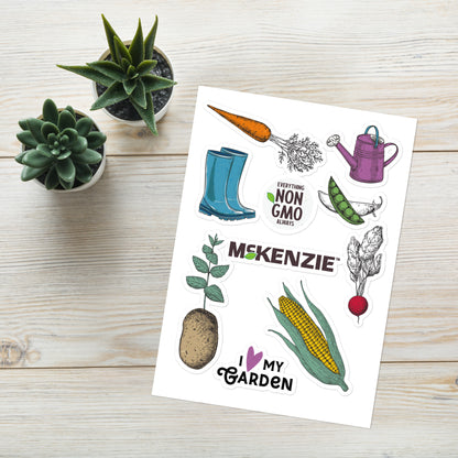 Sheet of gardening-themed stickers with plants and tools on a wooden surface.